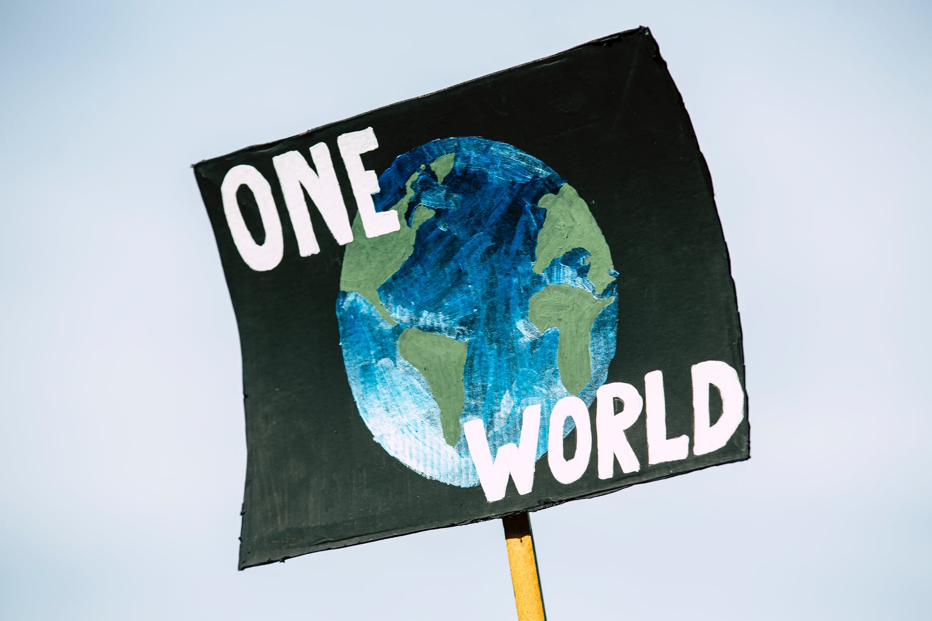 Picture of "one world" text with image of the Earth as a sign.